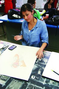 Woodlake student Natalia Frias works on her painting of a girl who is the victim of cyberbullying. Photo courtesy of the Tulare County Office of Education.