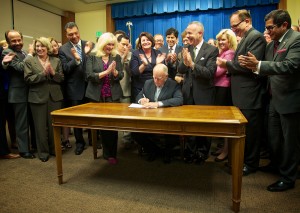 Governor Brown signs water bond legislation as Assembly Republican Leader Connie Conway (standing at left corner of table) and State Senator Jean Fuller (second from left) look on. Photo by Kelly Huston, Office of the Governor. 