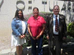 Julia Jimenez, her mother, and Paul Grenseman in front of the Tulare County Courthouse.