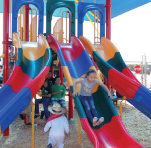 Five-year-old Darlene slides down the new playground equipment at the Plainview Neighborhood Park grand opening in June. 